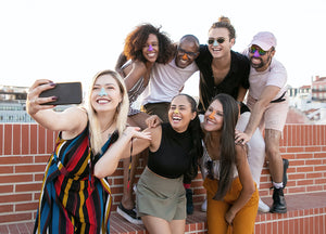 Group of friends with colorful nose sunscreen smiling for a picture